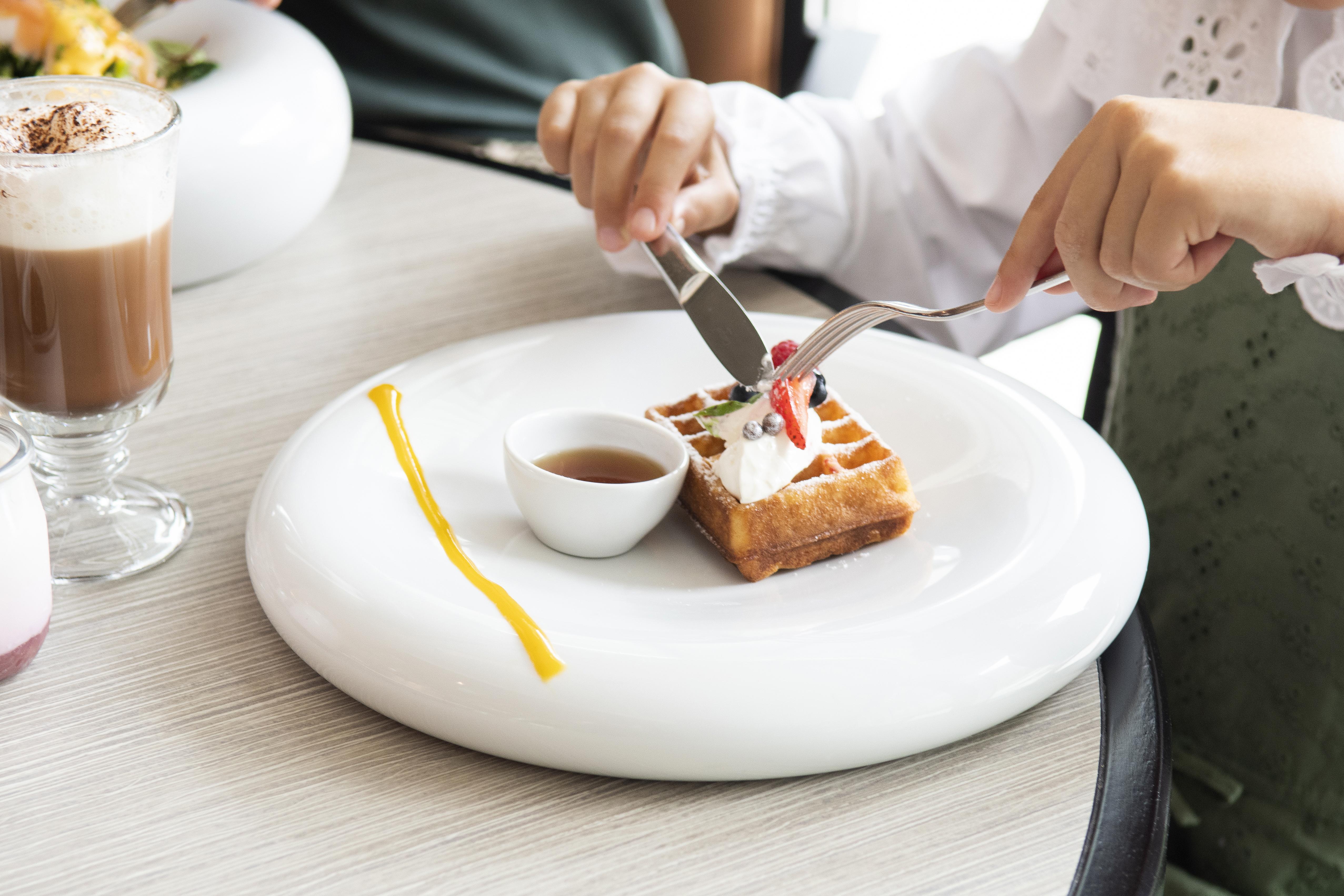 Epic Sana Lisboa Hotel Екстер'єр фото A woman using a knife and fork to cut a dessert